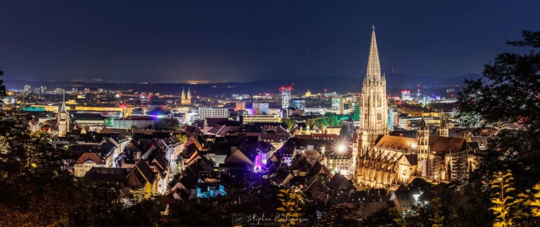 Blick auf Freiburg bei Nacht vom Kanonenplatz mit Freiburger Münster im Vordergrund