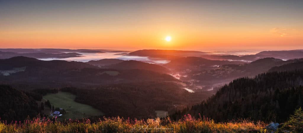 Panorama-Sonnenaufgang vom Bismarckturm auf dem Feldberg mit Blick über den Schwarzwald und neblige Täler