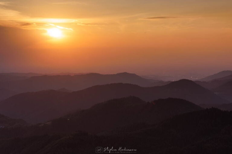 Sonnenuntergang am Buchkopfturm im Schwarzwald mit gestaffelten Hügeln und warmer Abendstimmung