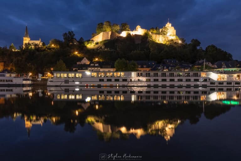 Saarburg mit beleuchteter Burg, Schiff und Spiegelung in der Saar zur blauen Stunde
