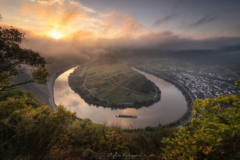 Moselschleife bei Bremm zum Sonnenaufgang mit Nebel und einem Schiff auf der Mosel