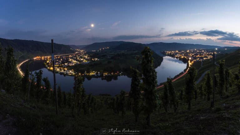 Moselschleife bei Kröv zur späten blauen Stunde mit Blick über Weinberge, Mosel und beleuchtete Orte