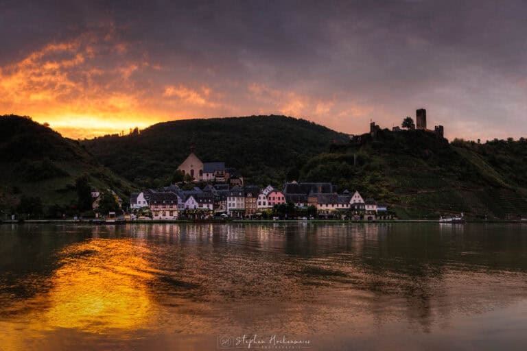 Beilstein an der Mosel mit Burg Metternich und leuchtendem Morgenhimmel über der Mosel